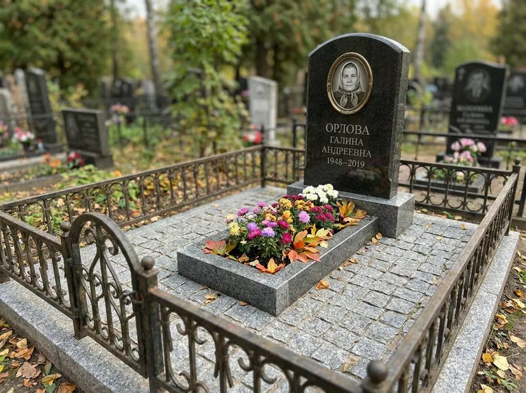 Благоустроенное захоронение с гранитной плиткой, оградой и цветником в Пензе