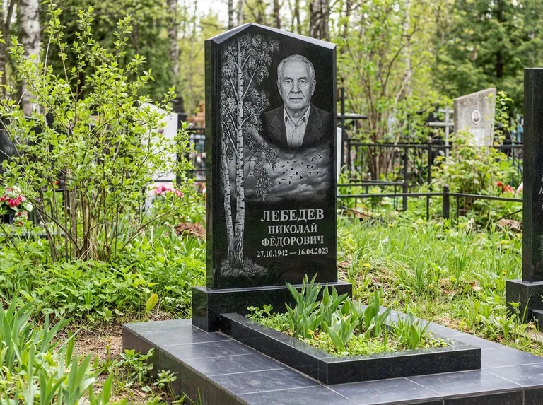 Памятник с гравировкой берёзы: вертикальная стела со скошенным верхом — берёза и стая птиц в небе, гранитный цоколь с тёмной плиткой, работа «Лебедев» в Пензе