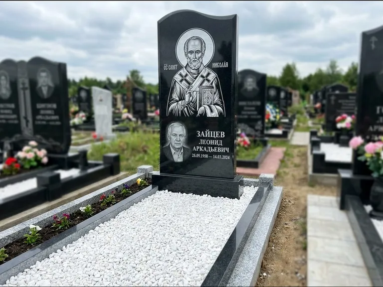 Памятник с гравировкой иконы: стела с крестообразным навершием — икона в резной рамке-киоте, газон без ограды, стриженая трава, работа «Раевская» в Пензе