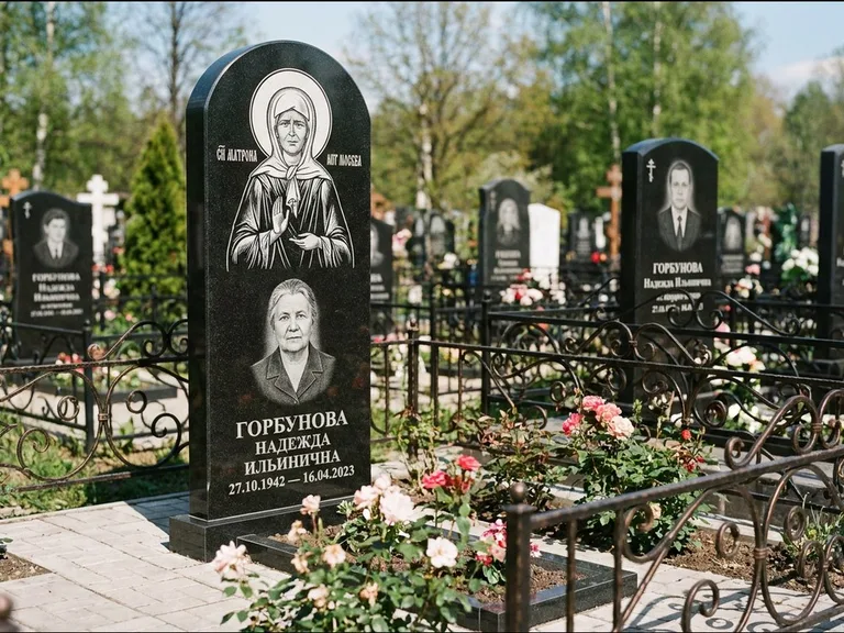 Памятник с гравировкой иконы: стела с арочным верхом и киотом под образ — гравировка образа Матроны Московской, гранитный цоколь с тёмной плиткой, работа «Ковалёв» в Пензе