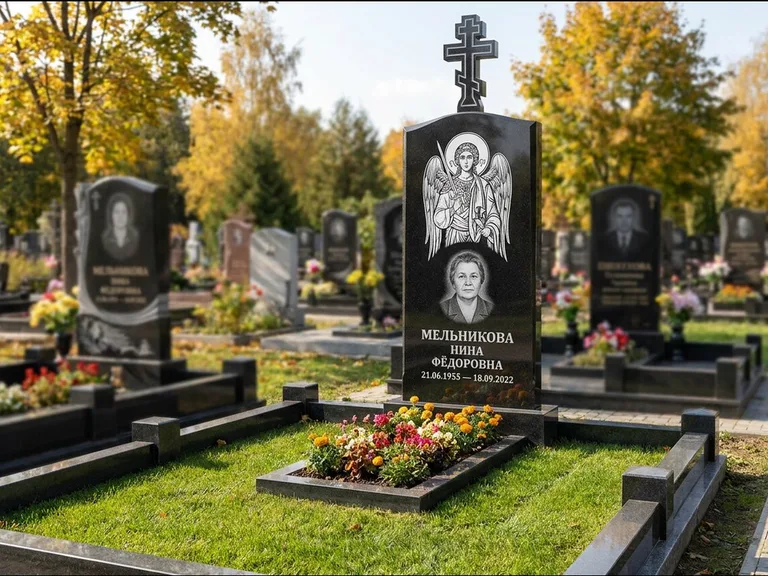 Памятник с гравировкой иконы: округлая стела-медальон с ликом — гравировка Богородицы «Семистрельная», луговые травы и полевые цветы за участком, работа «Гущин» в Пензе