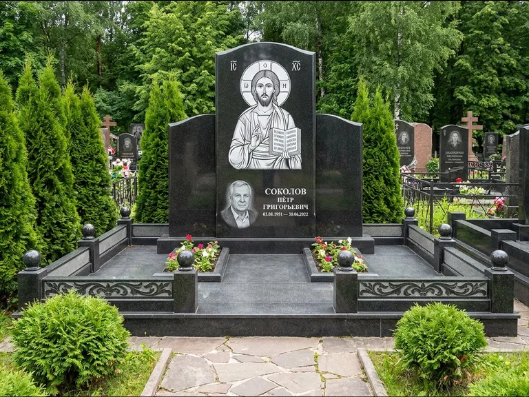 Памятник с гравировкой иконы: широкая горизонтальная лежачая плита-стела — икона в резной рамке-киоте, серая гравийная отсыпка с бордюром, работа «Богданова» в Пензе