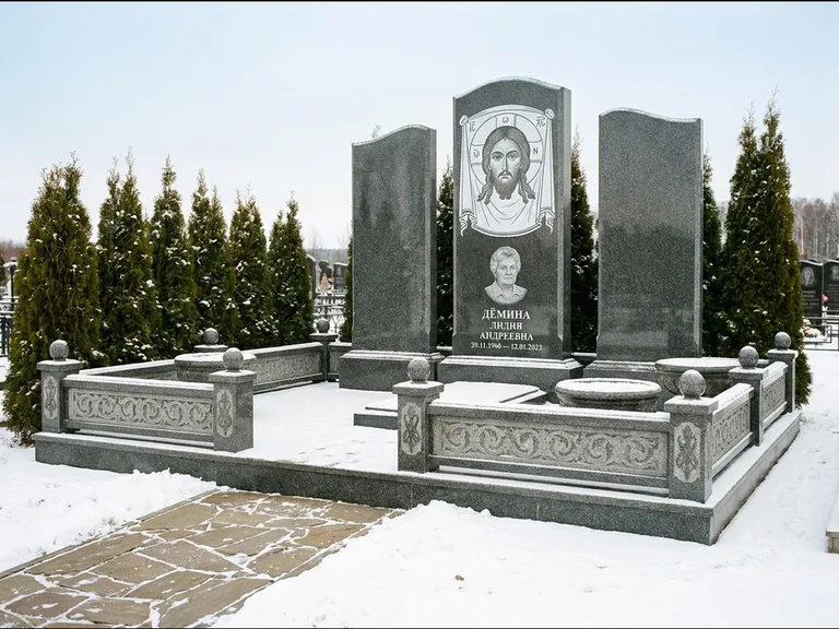 Памятник с гравировкой иконы: узкая вертикальная стела-пилон с ликом — икона в резной рамке-киоте, открытая лужайка без ограды, работа «Одинцов» в Пензе