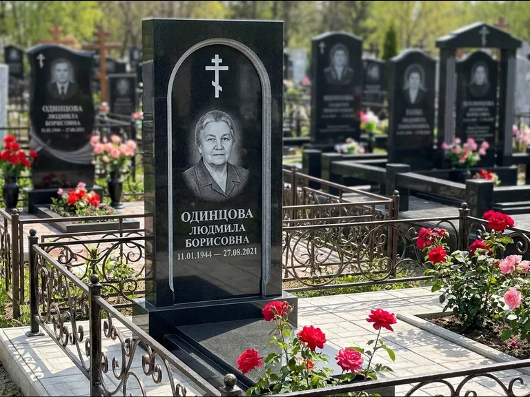 Памятник из чёрного гранита — скромная невысокая стела с крестом с терновым венцом, работа «Лаврентьева» в Пензе