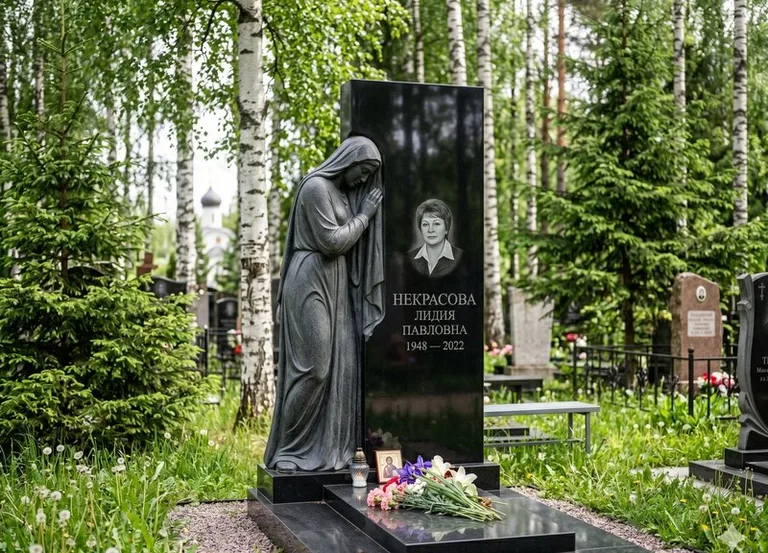 Гранитная фигура скорбящего мужчины у чёрной стелы в Пензе